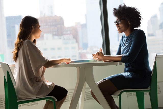 Two women chatting at a table