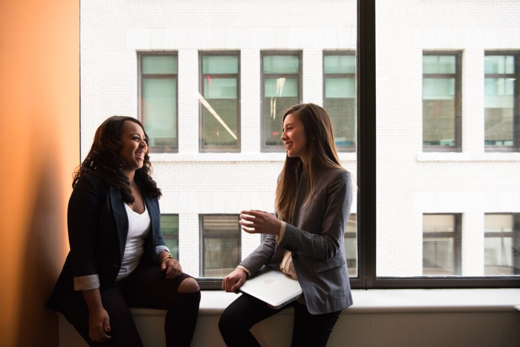 Two women chatting near a window